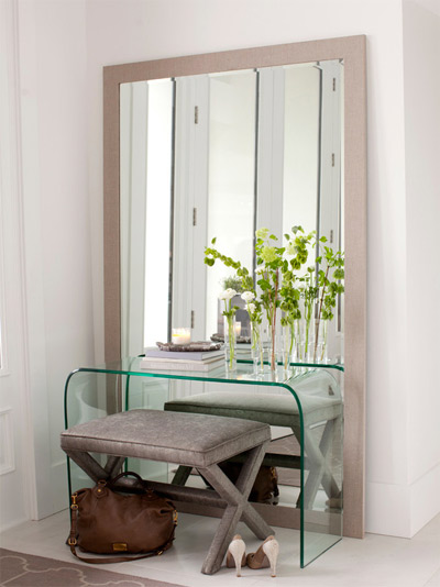 mirror propped against the wall behind a glass table